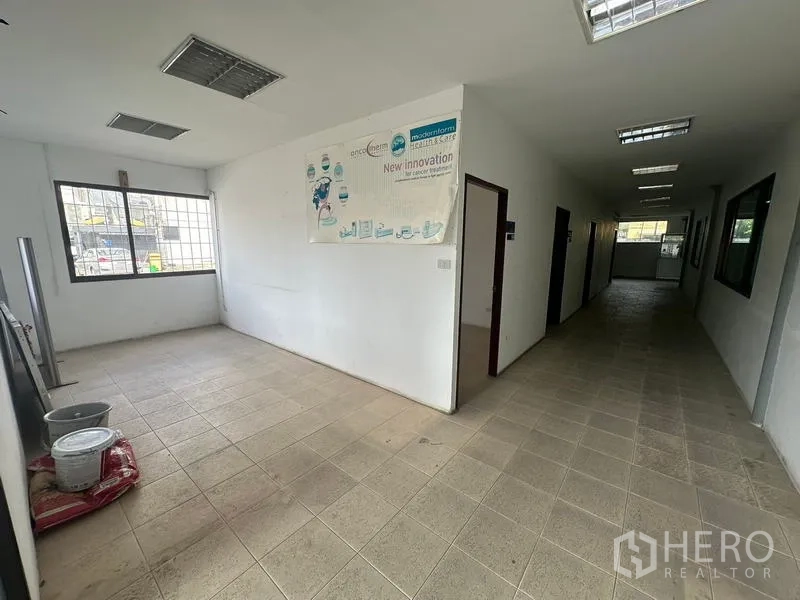 Warehouse for rent in Suan Luang, Bangkok - Ground-floor office hallway with tiled floor and windowed rooms.