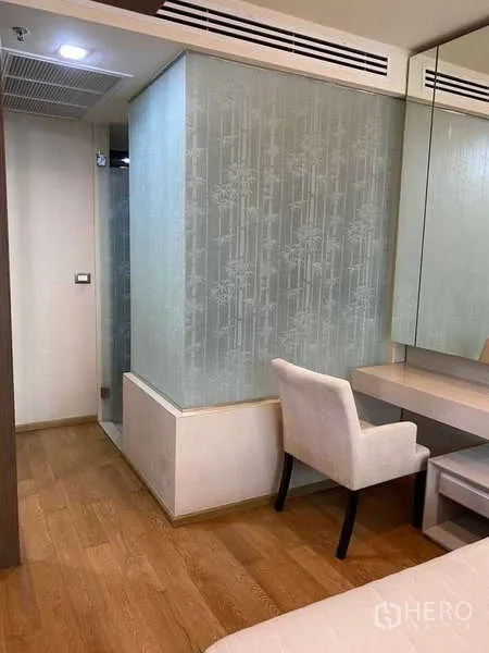 Condominium for rent in Bang Rak, Bangkok - Bedroom corner with dressing table and textured glass wall.