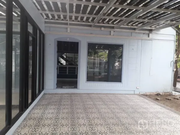 Detached House for rent in Watthana, Bangkok - Covered terrace with patterned tiles and a large window at a detached house in Watthana, Bangkok.