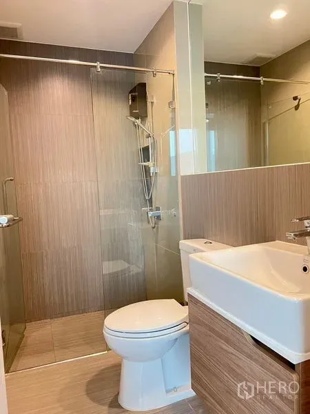 Townhouse for rent in Saphan Sung, Bangkok - Contemporary bathroom featuring a glass-enclosed shower, wall-hung vanity and toilet.