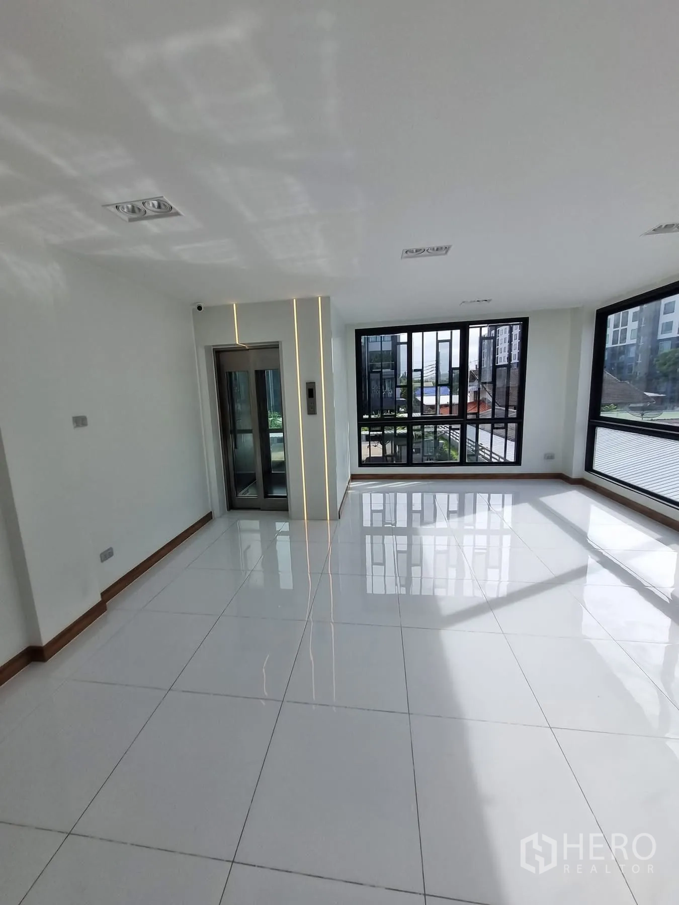 Home Office for rent in Khlong Toei, Bangkok - Open-plan ground floor space with large windows and a glass elevator.