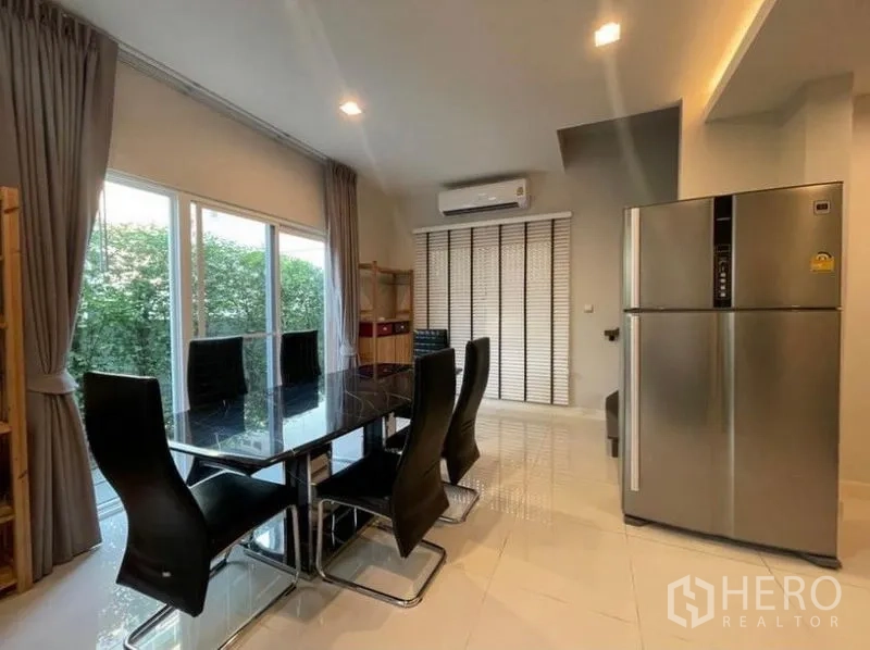 Detached House for rent in Lat Krabang, Bangkok - Dining area with black glass table, six chairs, large windows and stainless fridge