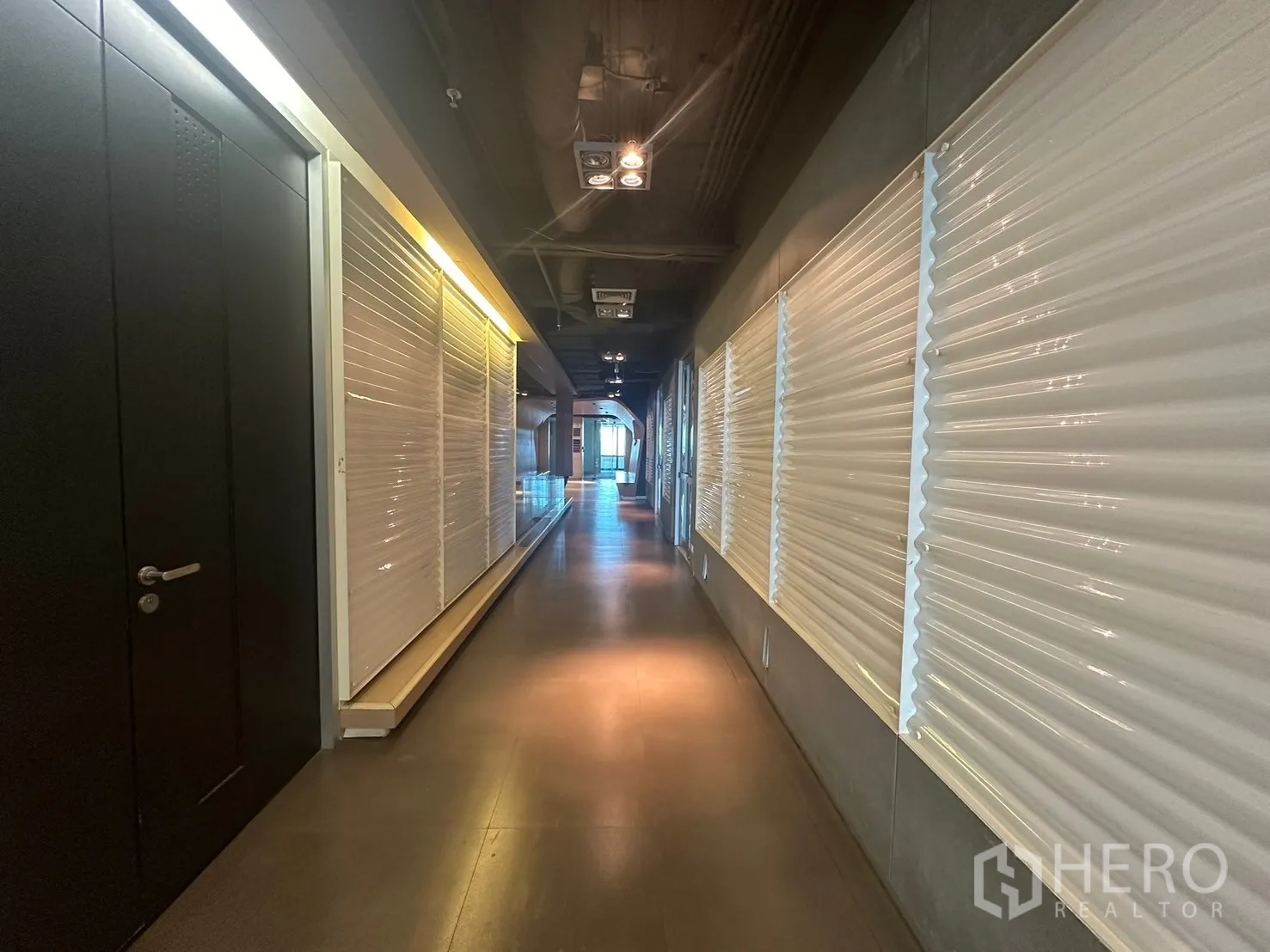 Office Space for rent in Khlong Toei, Bangkok - Office corridor with shuttered wall panels and a black door.