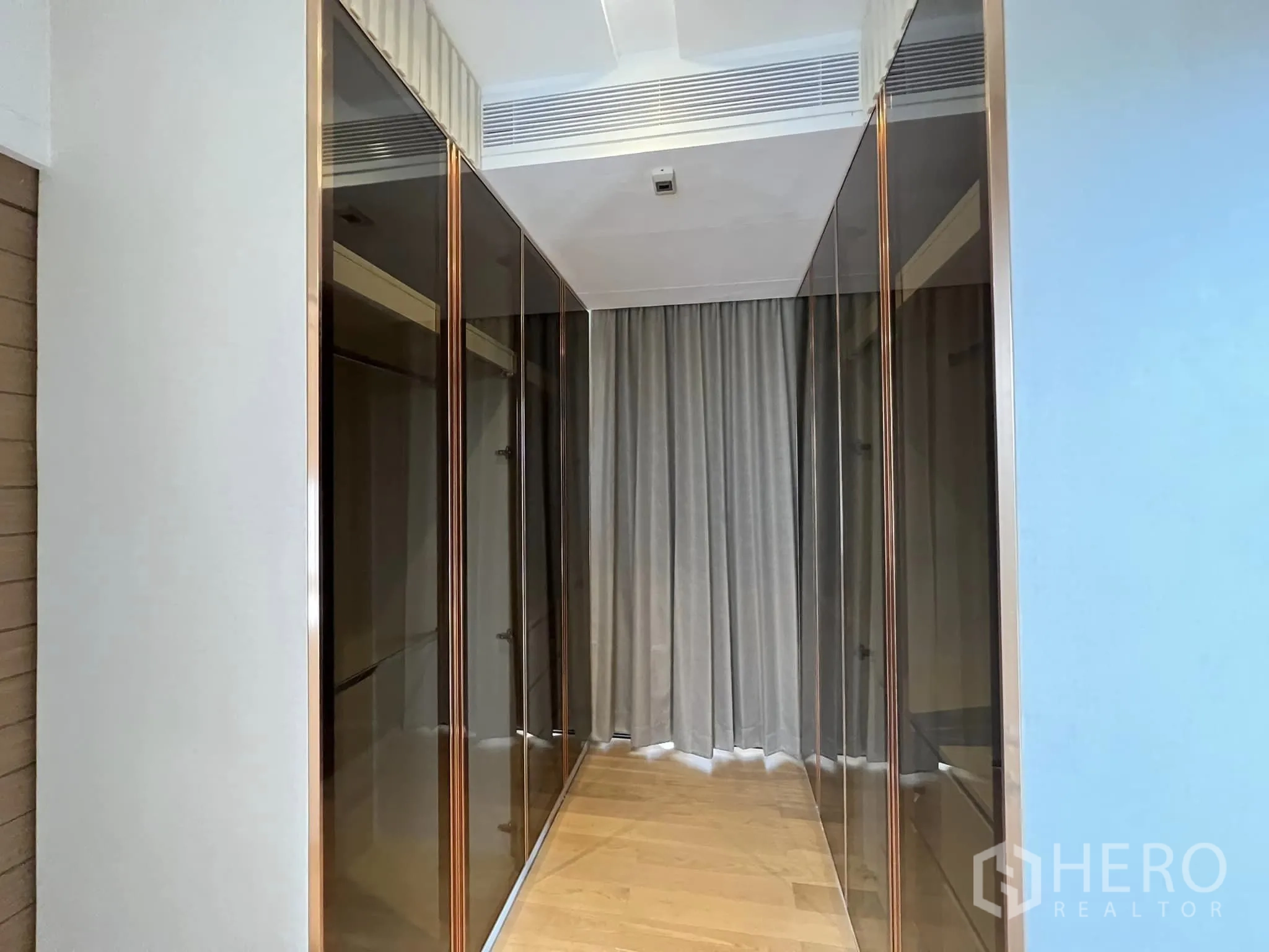 Detached House for rent or sale in Yan Nawa, Bangkok - Hallway lined with reflective glass wardrobes and curtains.