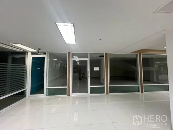 Retail Space for rent - Mall-facing glass storefront with clear display windows and glossy tiled walkway.