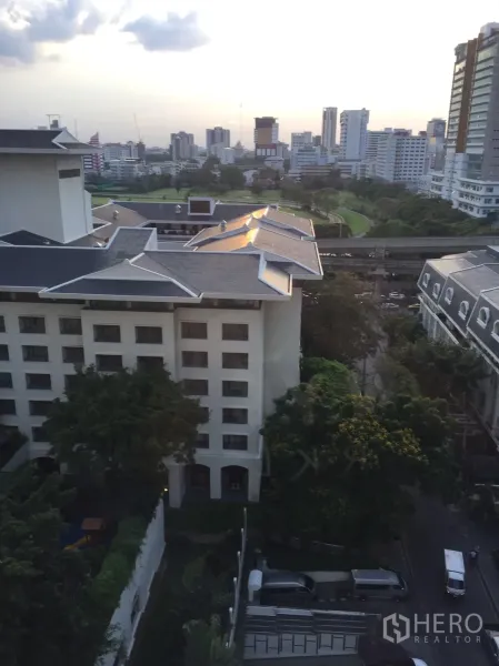 คอนโด ให้เช่าในPathum Wan, Bangkok - มุมมองเมืองชั้นสูง เห็นสกายไลน์ พื้นที่สีเขียว และรางรถไฟฟ้า BTS ยามเย็น