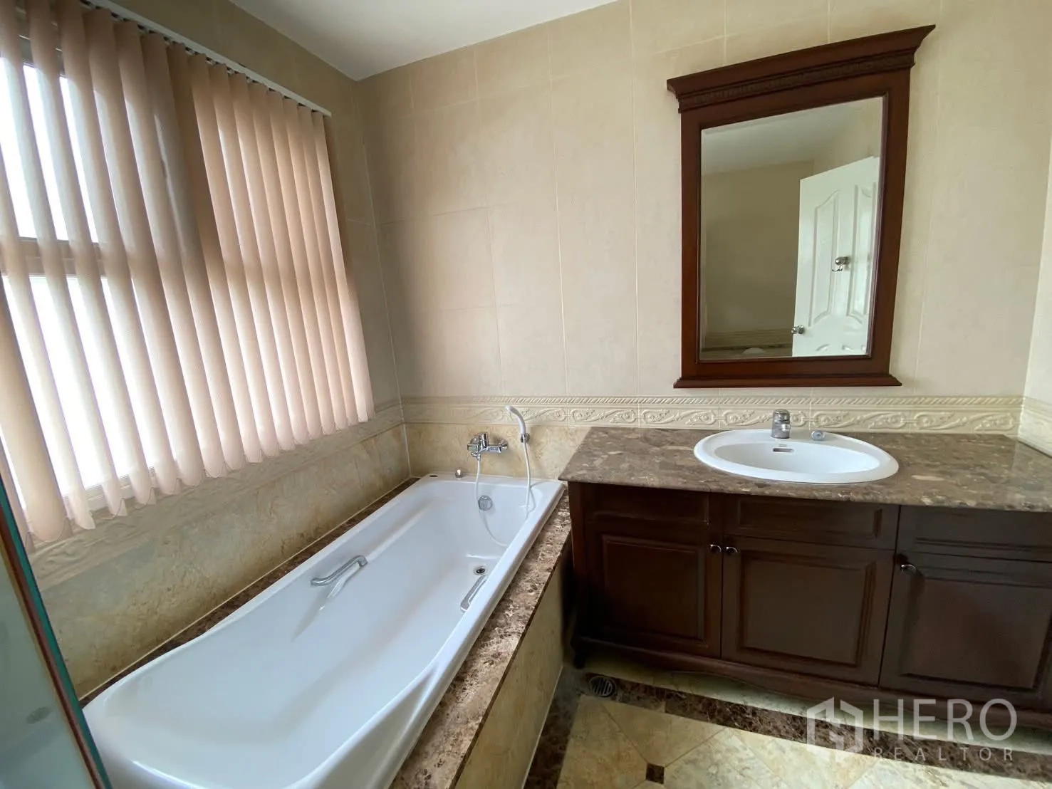 Detached House for rent in Phra Khanong, Bangkok - Bathroom featuring a bathtub, marble countertop vanity with sink, wall mirror, tiled walls, and blinds.