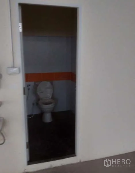 工厂 for rent in Ban Phaeo, Samut Sakhon - 厂房内的简洁卫生间，配坐便器与瓷砖墙面。