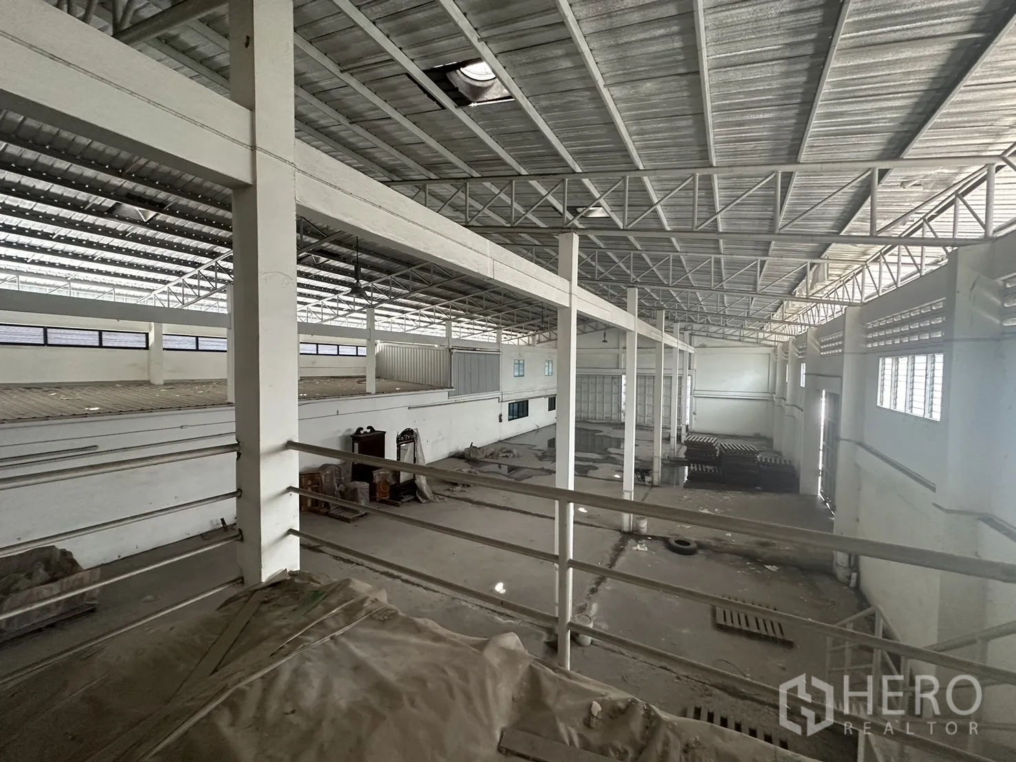 Factory for rent or sale in Prawet, Bangkok - Elevated view across the warehouse from the mezzanine showing truss roof and wide span.