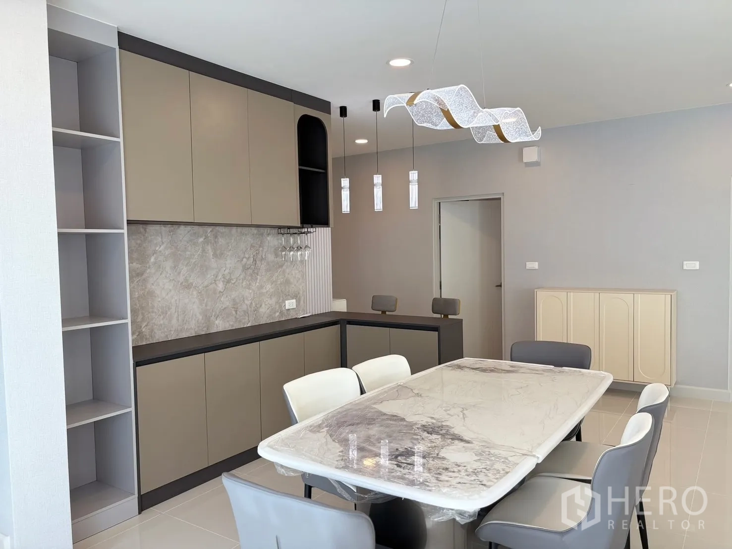 บ้าน for rent in Bang Phli, Samut Prakan - ห้องอาหารโปร่งพร้อมตู้เก็บของเต็มผนัง แผงหิน และโคมไฟดีไซน์.