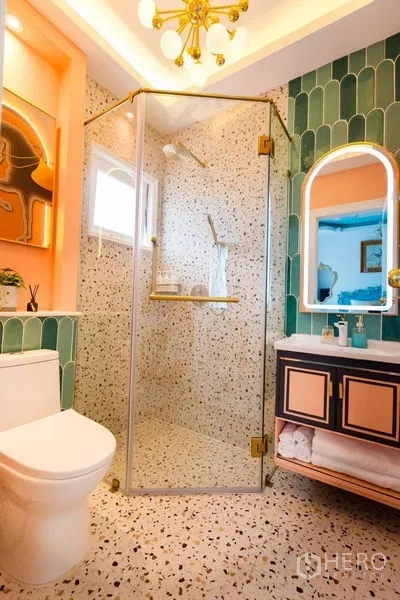 Townhouse for rent in Lat Phrao, Bangkok - Stylish bathroom with green wall tiles, terrazzo floor, glass shower and gold accents.
