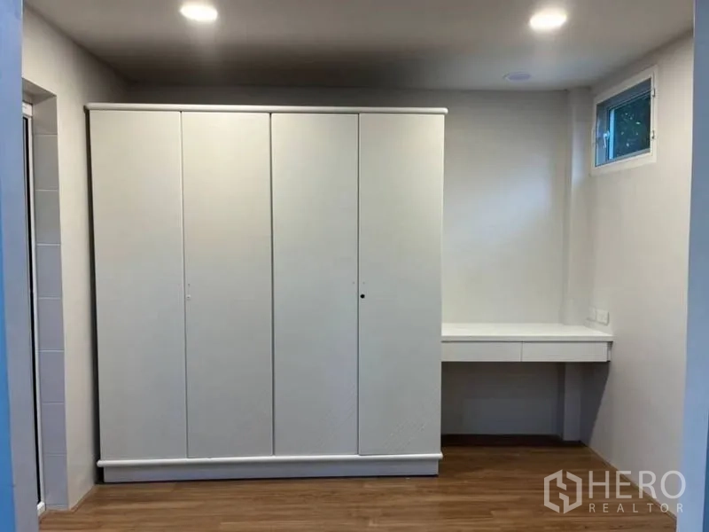 Detached House for rent in Samut Prakan - Built‑in white wardrobe with dressing desk and small window above.