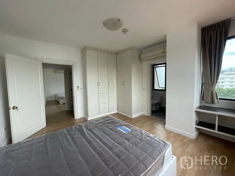 Condominium for rent in Watthana, Bangkok - Second bedroom with fitted wardrobes and access to an ensuite bathroom.