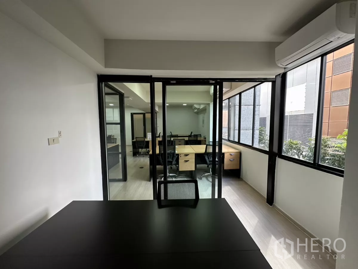 สำนักงาน ให้เช่าในWatthana, Bangkok - มุมมองจากห้องส่วนตัวผ่านประตูกระจกสไลด์ไปยังโถงทำงานและหน้าต่างยาว