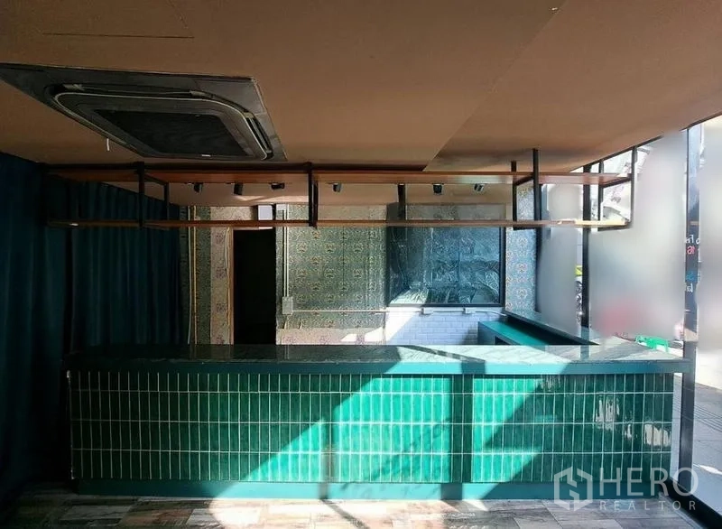Retail Space for rent in Bang Rak, Bangkok - Interior service counter clad in green tiles with overhead shelving and spotlights.