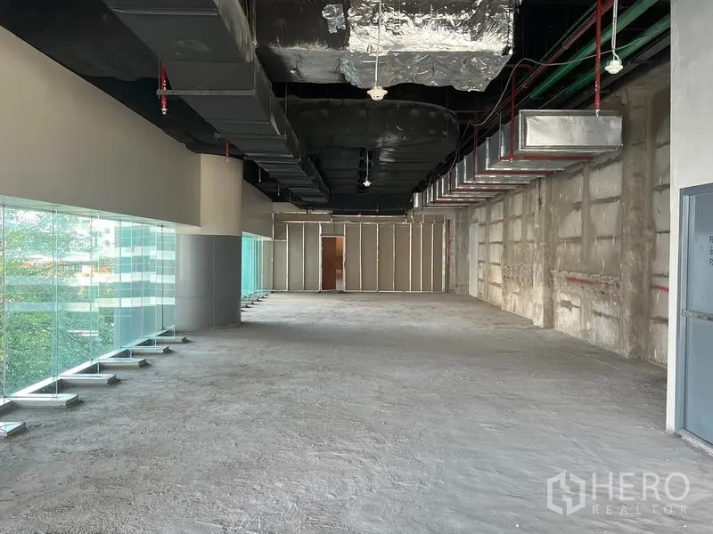 Retail Space for rent in Bang Rak, Bangkok - Open-plan retail unit with panoramic glazing and unfinished concrete floor.