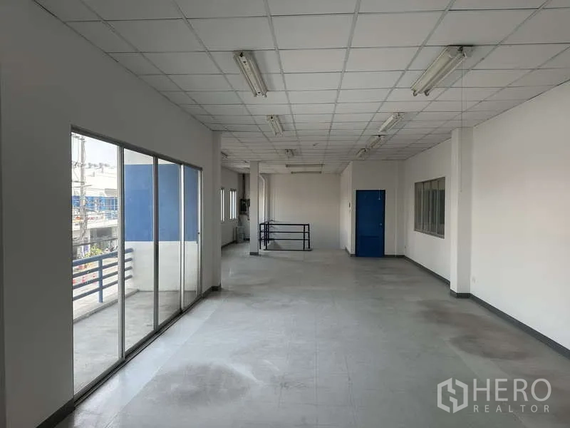 工厂 出租在Khlong Luang, Pathum Thani - 办公室走道，落地推拉门通向阳台，配蓝色服务门。
