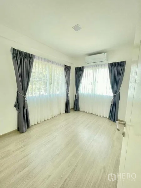 联排别墅 出租或出售在Prawet, Bangkok - 明亮次卧，转角窗、双层窗帘与空调。