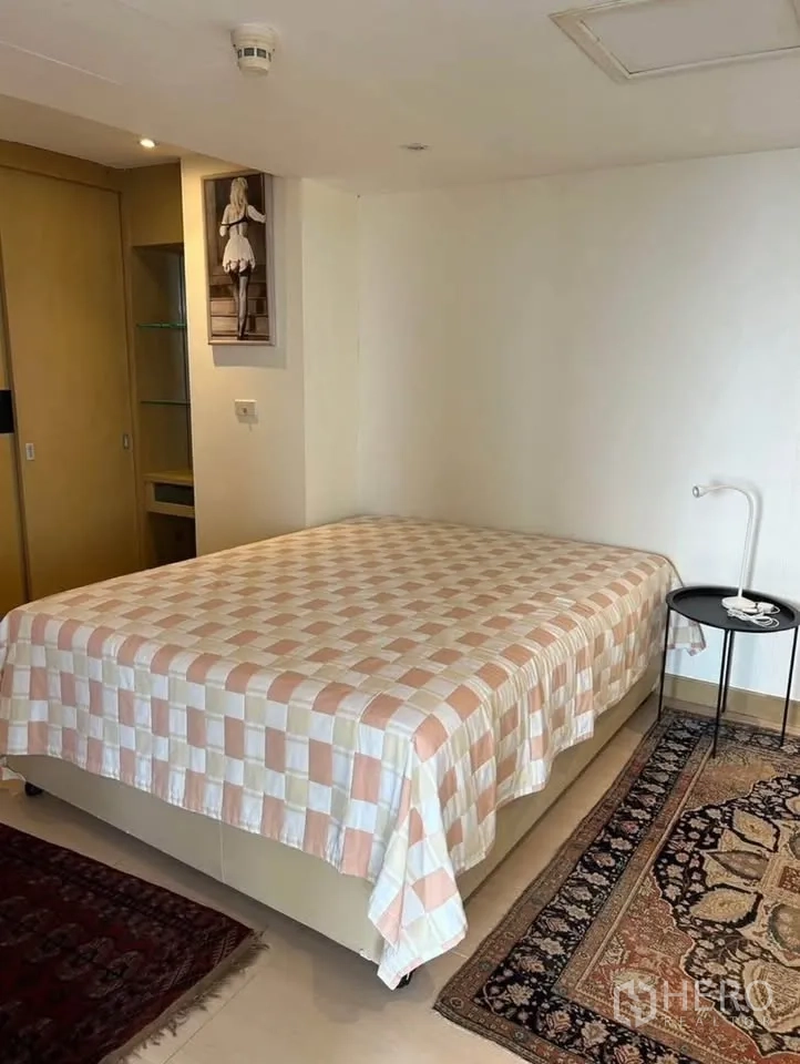 公寓 出租或出售在Yan Nawa, Bangkok - 第二卧室，带收纳柜、床头桌与图案地毯。