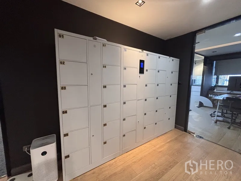 Office Space for rent in Bang Rak, Bangkok - Row of white staff lockers next to a meeting room and corridor.