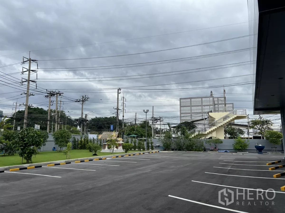 Warehouse for rent in Yan Nawa, Bangkok - Front car park and landscaped verge near the main road and overhead power lines.