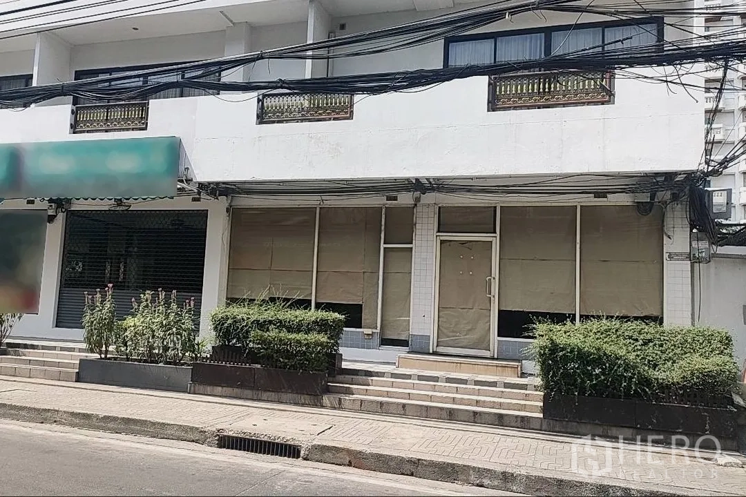零售空间 出租在Khlong Toei, Bangkok - 临街店面，宽幅玻璃橱窗、台阶入口与绿植花坛，位于曼谷澎蓬区域。