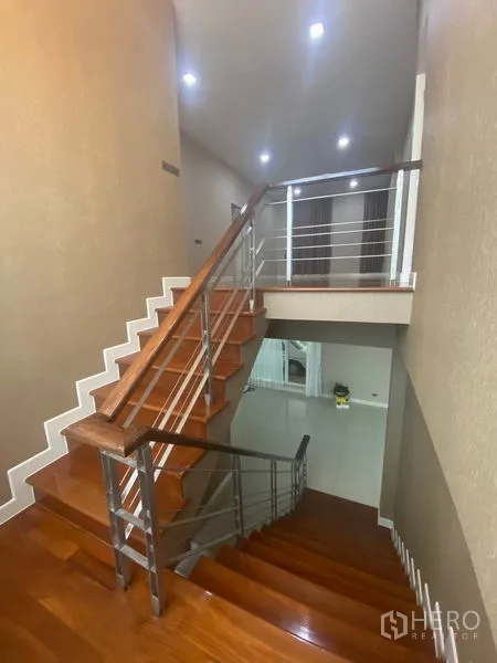 独立式住宅 出租在Prawet, Bangkok - 抛光实木楼梯配不锈钢扶手，通往二层过道。