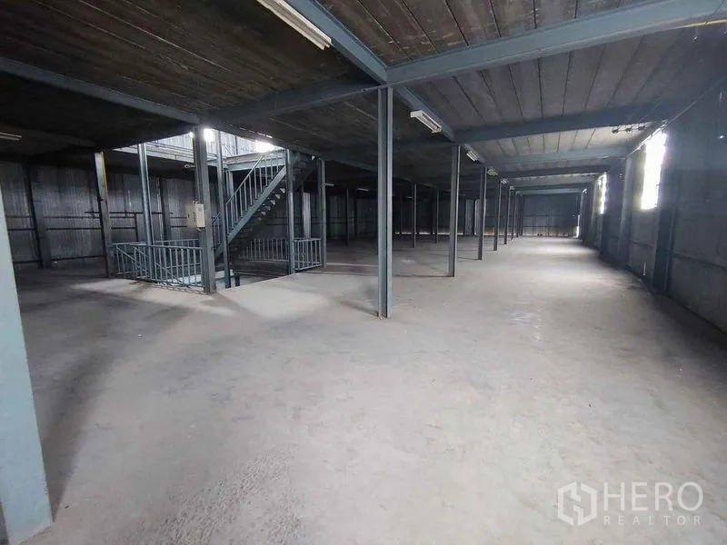 Warehouse for rent in Samut Sakhon - Mezzanine storage level with steel staircase and columns for additional space.