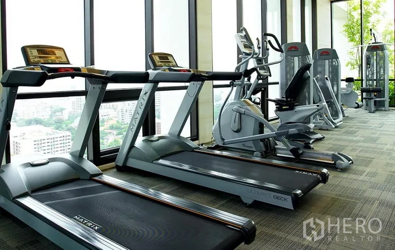 Condominium for rent or sale in Phaya Thai, Bangkok - Fitness room with treadmills, bikes and weight machines facing city views.