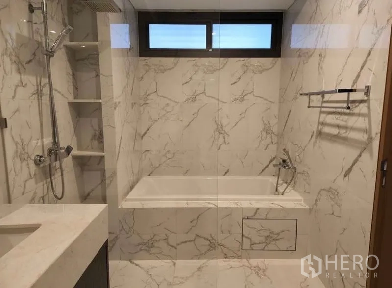 Townhouse for sale in Yan Nawa, Bangkok - Luxury bathroom with marble-effect tiles, built-in bathtub, glass shower and vanity.