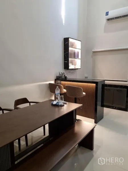 Townhouse for rent - Compact home bar with backlit display cabinet and two stools.