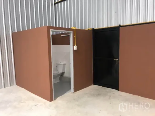 货栈 出租在Khlong Luang, Pathum Thani - 仓库内设独立卫生间和黑色服务门。