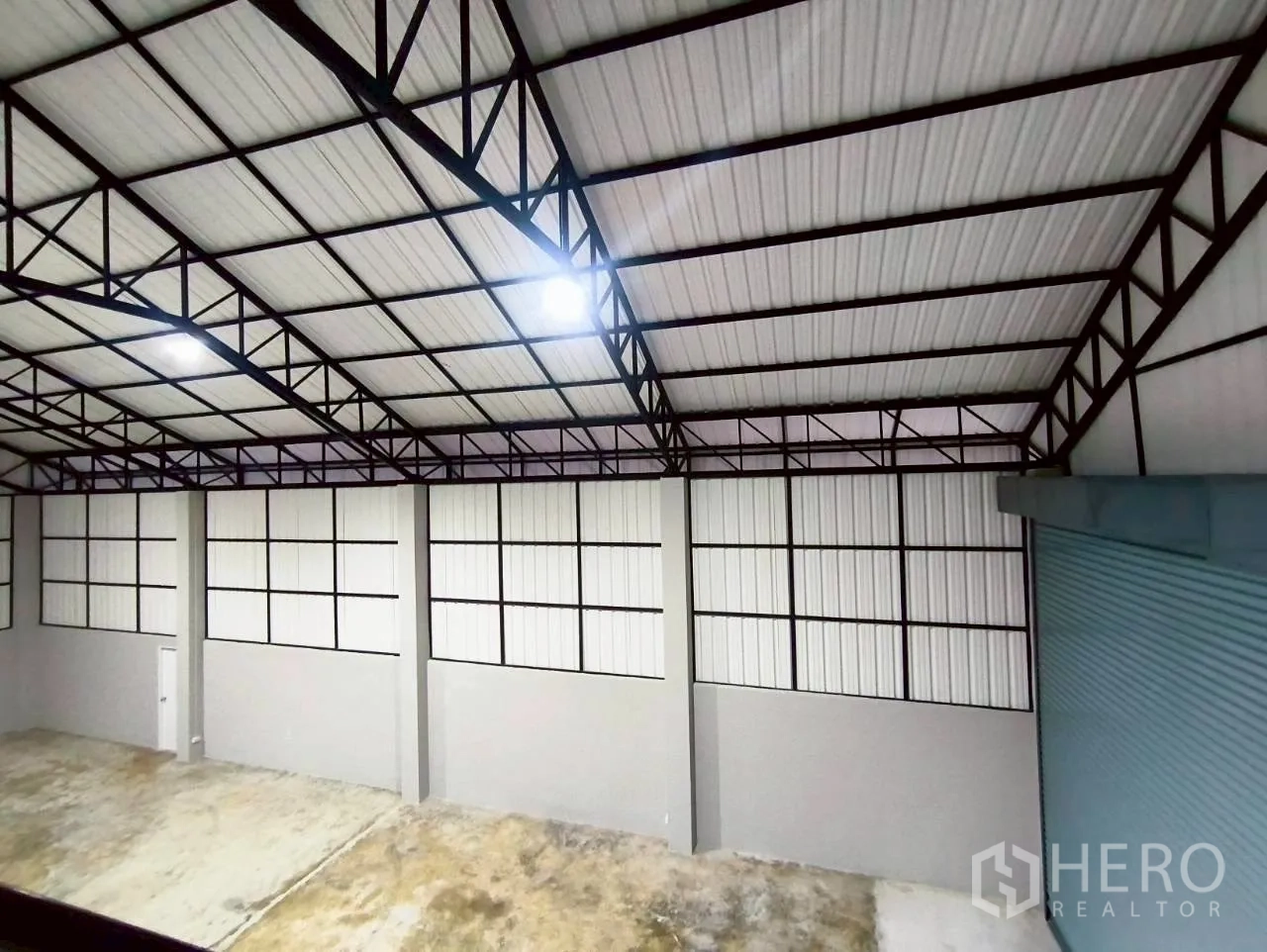 Warehouse for rent in Mueang Nonthaburi, Nonthaburi - View of the warehouse roof structure and wall panels from inside.