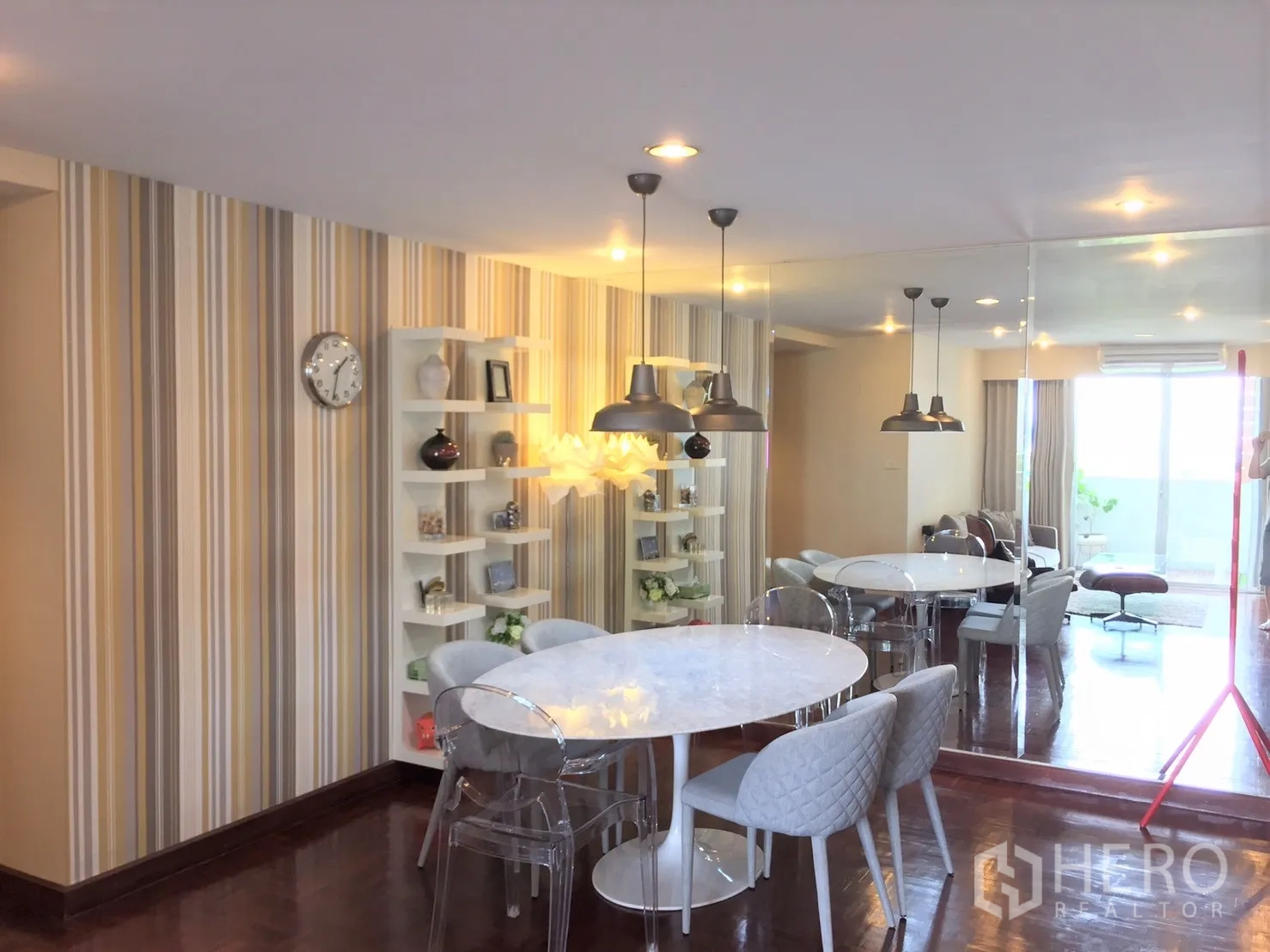 公寓 出租在Watthana, Bangkok - 用餐区设圆形大理石餐桌、吊灯、嵌入式搁架与镜面墙。