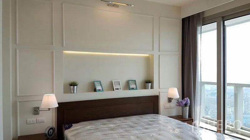 公寓 出租在Khlong San, Bangkok - 采光充足的卧室，床头壁龛灯与阳台门眺望天际线