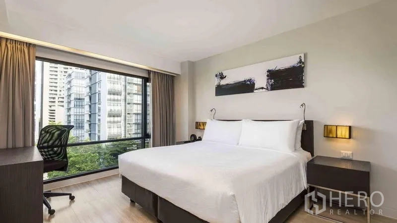 อพาร์ทเมนท์ ให้เช่าในWatthana, Bangkok - ห้องนอนเตียงคิงพร้อมโต๊ะทำงานและหน้าต่างกว้างมองเห็นวิวสกายไลน์กรุงเทพฯ