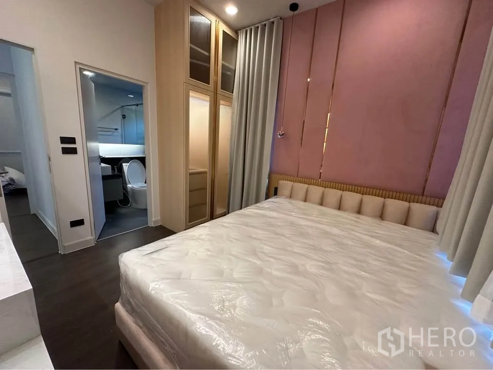Detached House for rent in Bang Kapi, Bangkok - Bedroom with built-in wardrobe and doorway to an ensuite bathroom.