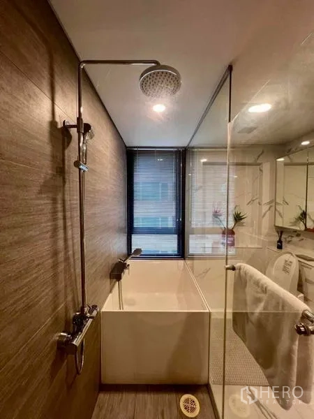 Condominium for rent - Bathroom with rain shower above a deep soaking tub and a window for natural light.