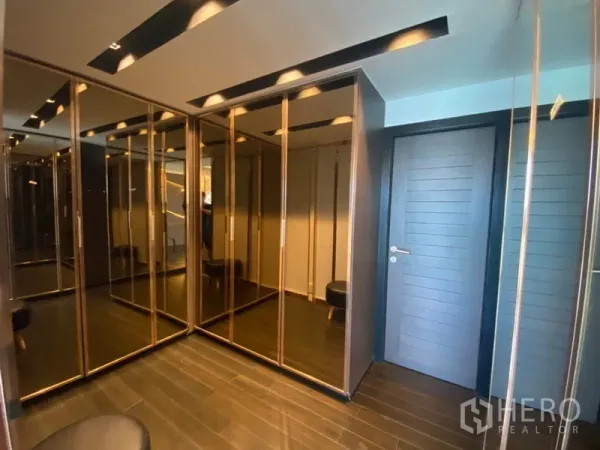 Townhouse for sale in Yan Nawa, Bangkok - Walk‑in wardrobe with mirrored floor‑to‑ceiling closets and recessed lighting.