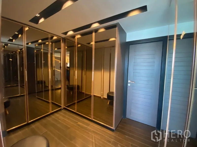 Townhouse for sale in Yan Nawa, Bangkok - Walk‑in wardrobe with mirrored floor‑to‑ceiling closets and recessed lighting.