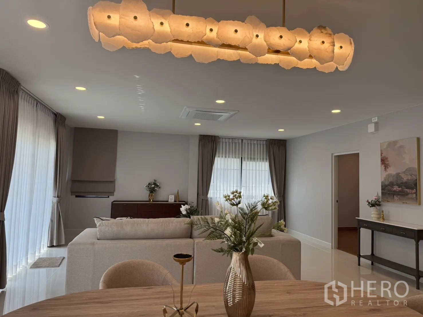 บ้าน for rent in Bang Phli, Samut Prakan - พื้นที่นั่งเล่นกว้าง โคมไฟแขวนดีไซน์เด่นเหนือโต๊ะอาหาร พร้อมผ้าม่านรอบด้าน