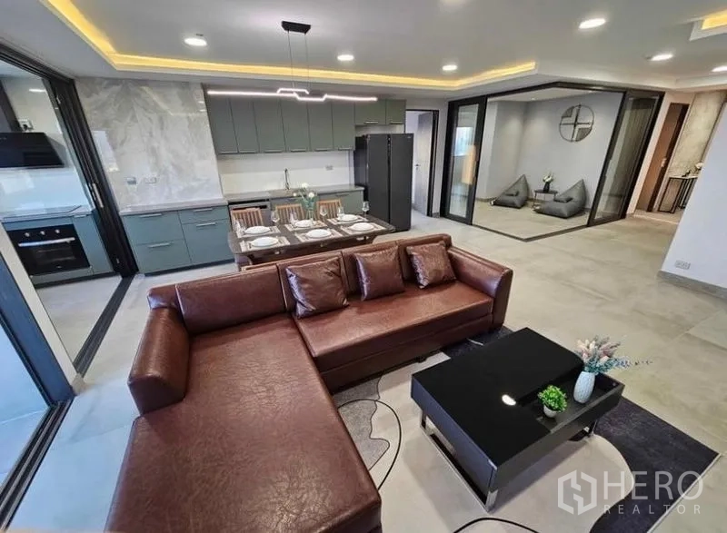 Condominium for rent or sale - Open-plan living with sofa, dining table and glass-walled lounge.