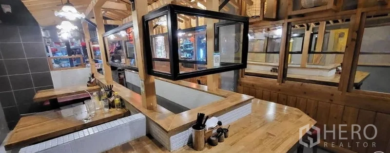 Shophouse for rent in Khlong Toei, Bangkok - Ground-floor restaurant seating area with wooden booths and service counter.
