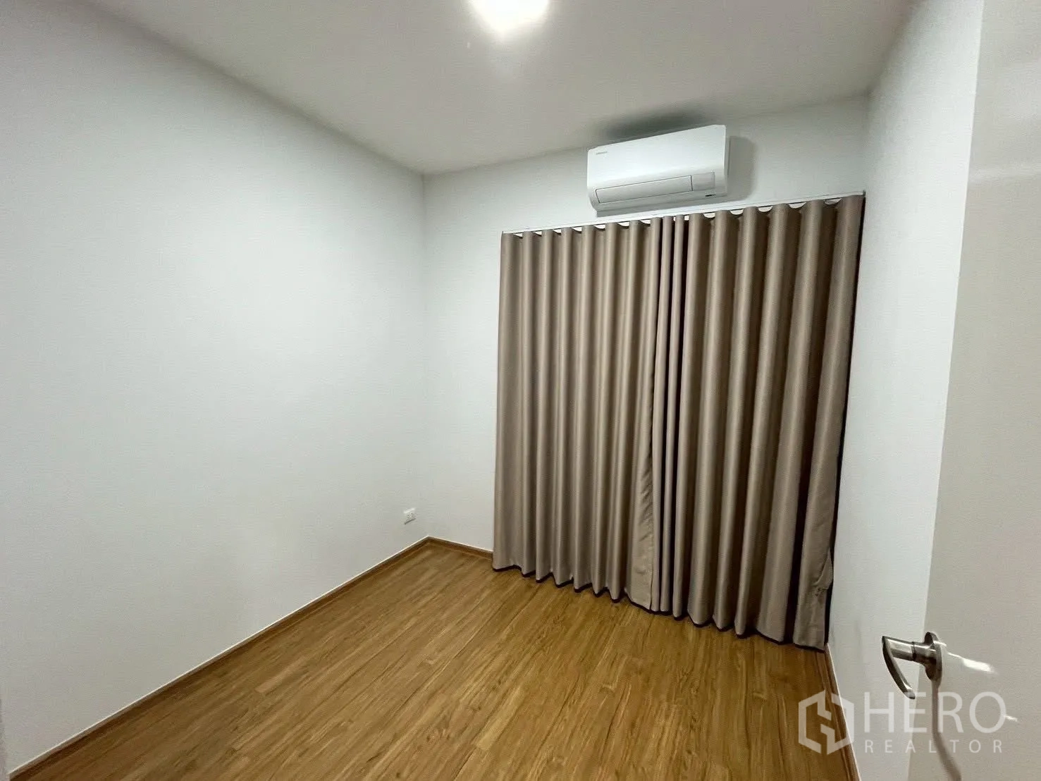 ทาวน์เฮาส์ for rent in Bang Phli, Samut Prakan - ห้องนอนโล่ง พื้นลายไม้ ผ้าม่าน และเครื่องปรับอากาศติดผนัง.