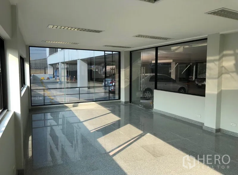 Office Space for rent in Khlong Toei, Bangkok - Glass-wrapped corner office space with views toward the parking area.