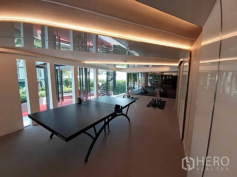 公寓 出租或出售在Watthana, Bangkok - 娱乐室配乒乓球台，旁为景观庭院。