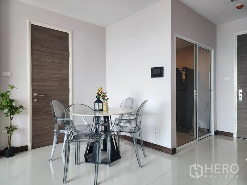 公寓 出租在Yan Nawa, Bangkok - 用餐角，圆形玻璃餐桌配透明椅，旁为玻璃隔断厨房