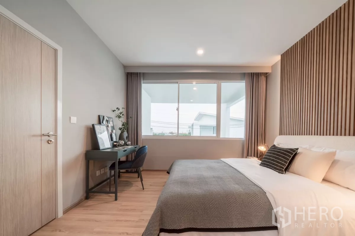 Detached House for rent in Saphan Sung, Bangkok - Master bedroom angle showing bed, wide window and writing desk.
