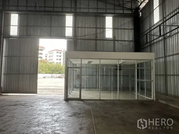 货栈 出租在Pak Kret, Nonthaburi - 室内入口处，高大滑门与玻璃隔断办公室朝向院区。