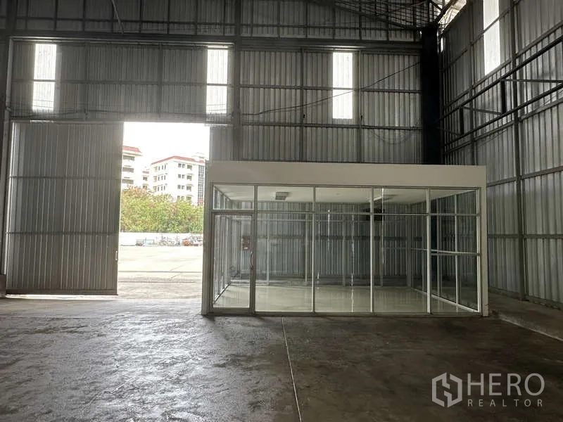 货栈 出租在Pak Kret, Nonthaburi - 室内入口处，高大滑门与玻璃隔断办公室朝向院区。
